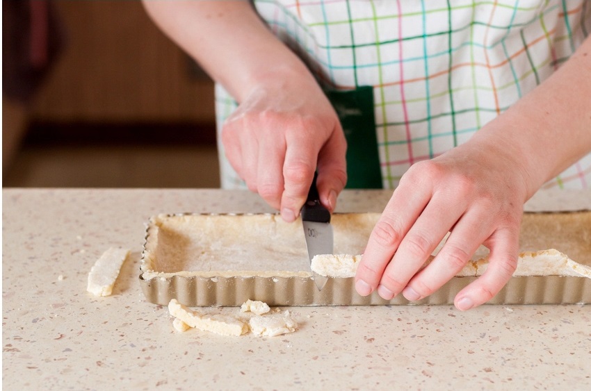 Trim the overhanging edges and prick the base a few times with a fork.